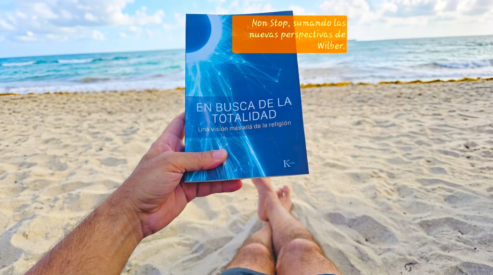 Persona leyendo un libro de crecimiento personal en una playa
